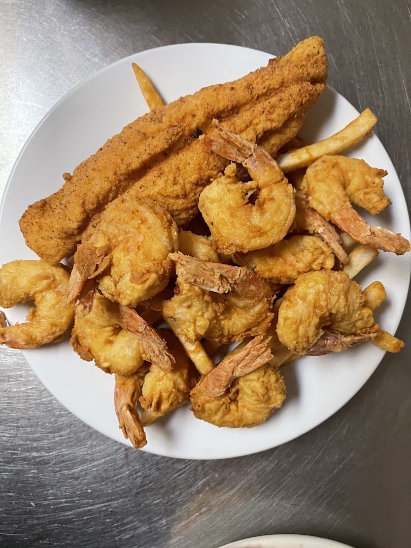 Plates of fried shrimp beside a salad bar.