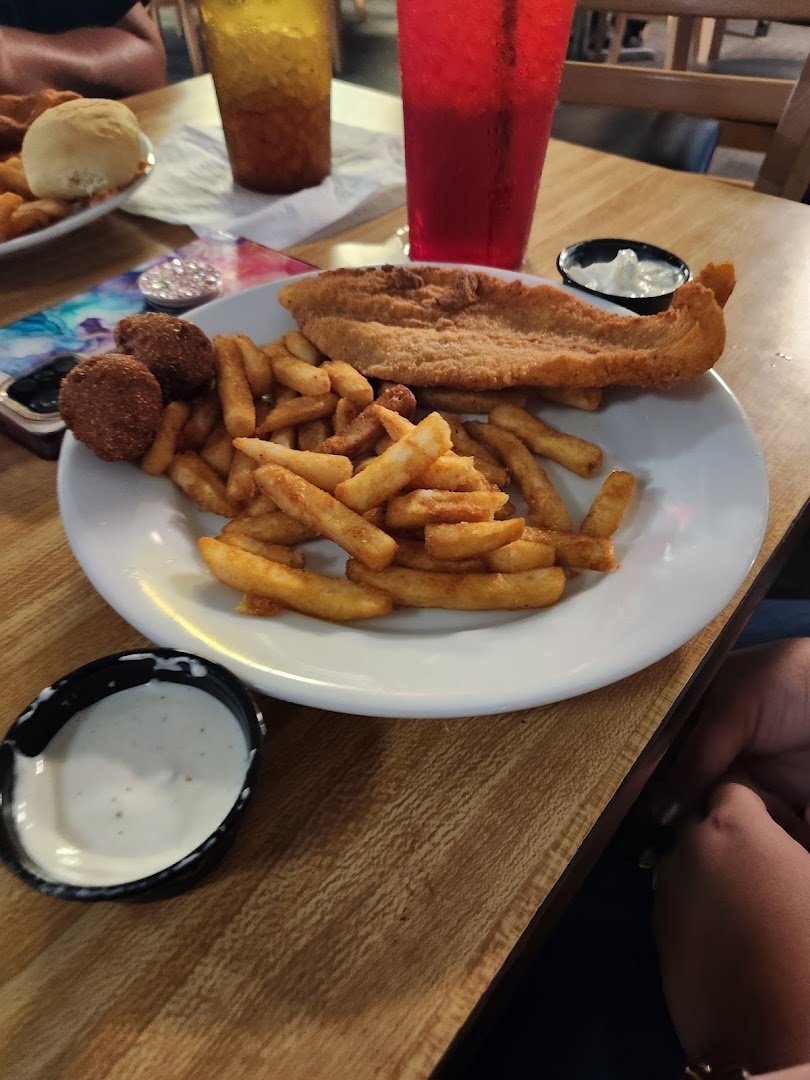 Plates of fried shrimp beside a salad bar.